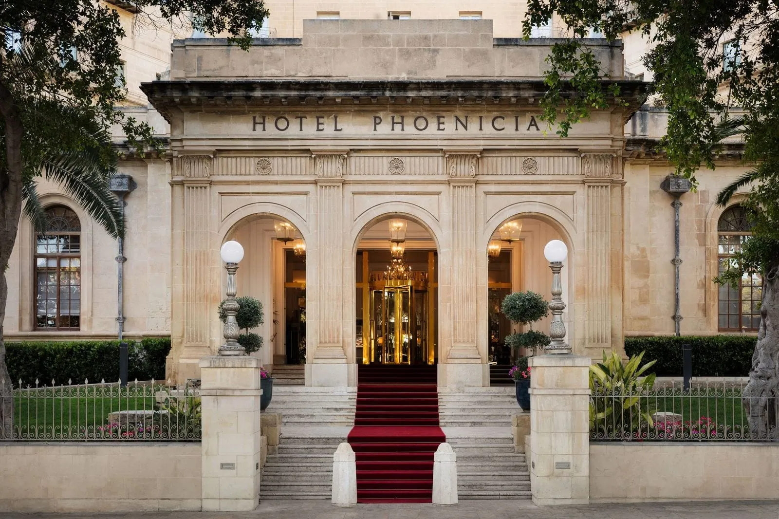The Phoenicia's arched entrance portico, with the hotel's name carved above the steps