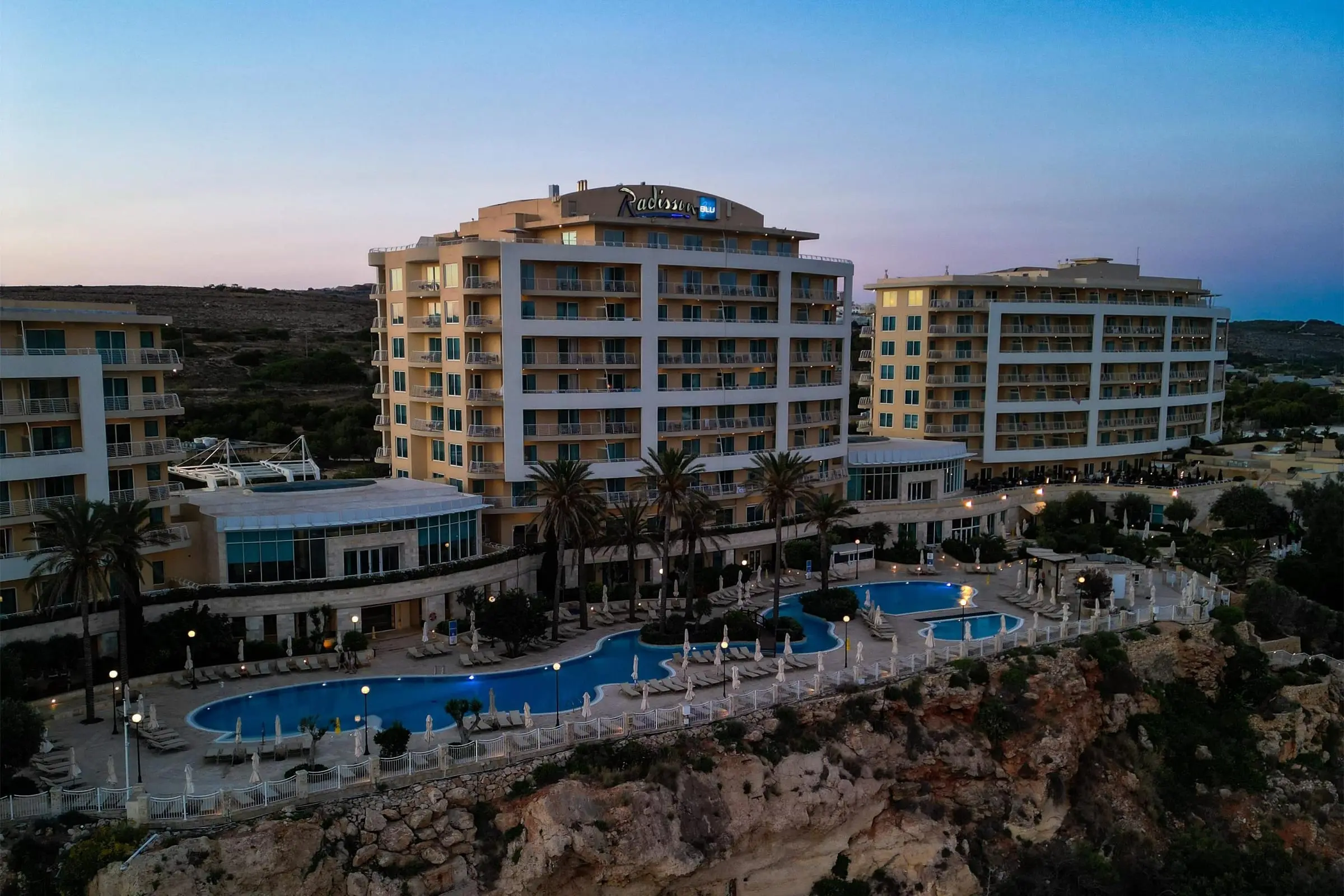 The Radisson Blu Resort & Spa, Golden Sands, and its pools on the clifftop at dusk