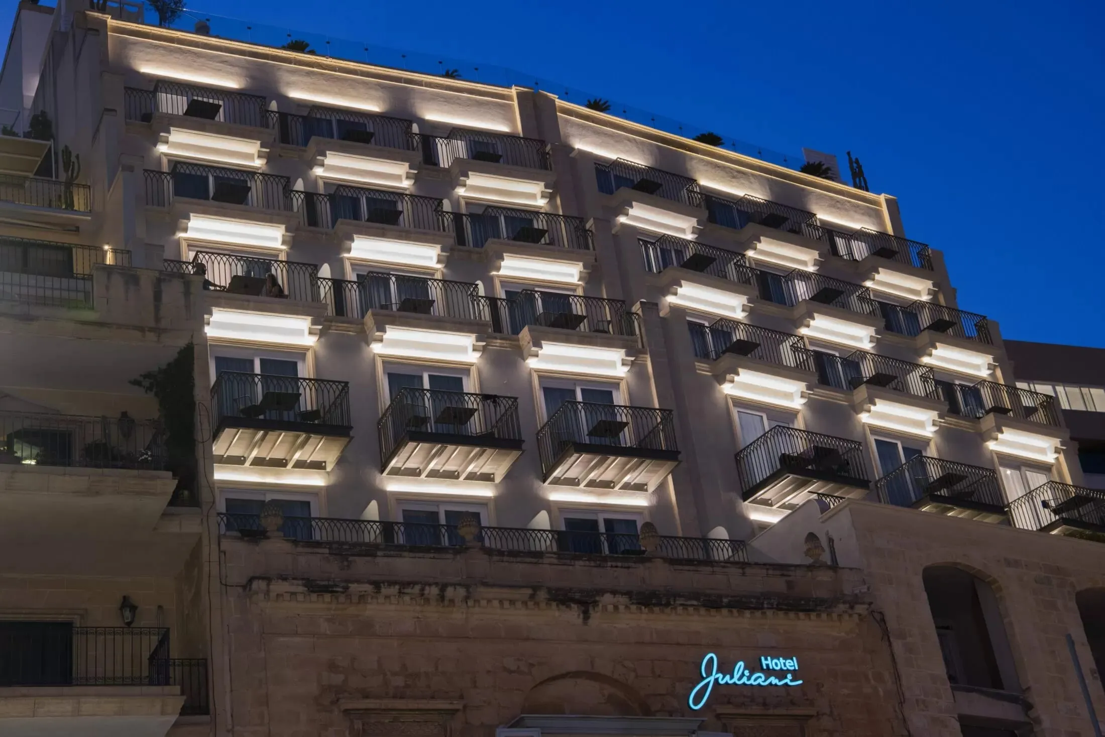 The facade of Hotel Juliani on Spinola Bay, St Julian’s, lit at dusk