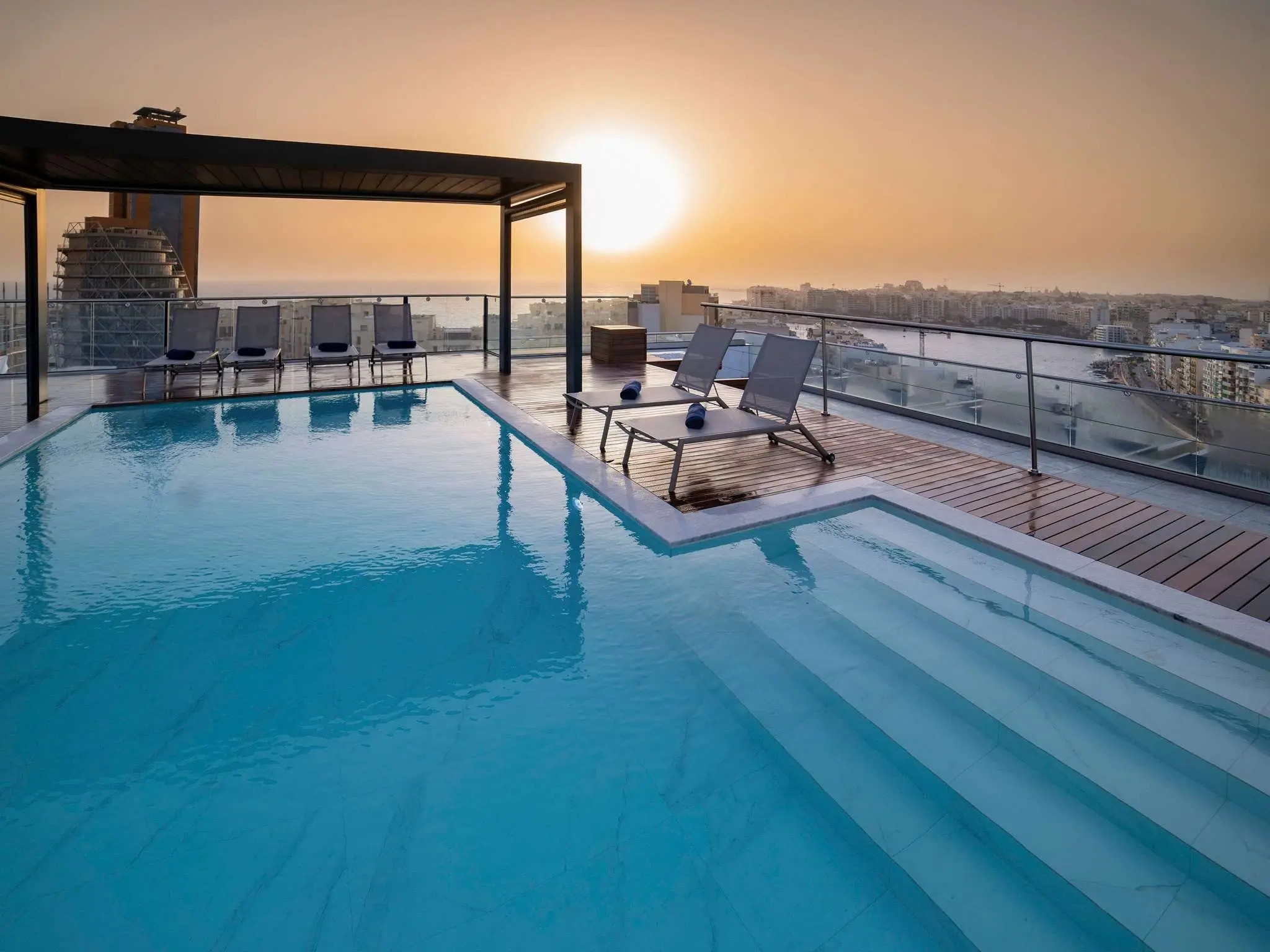 The rooftop pool at the Mercure St Julian’s at sunset