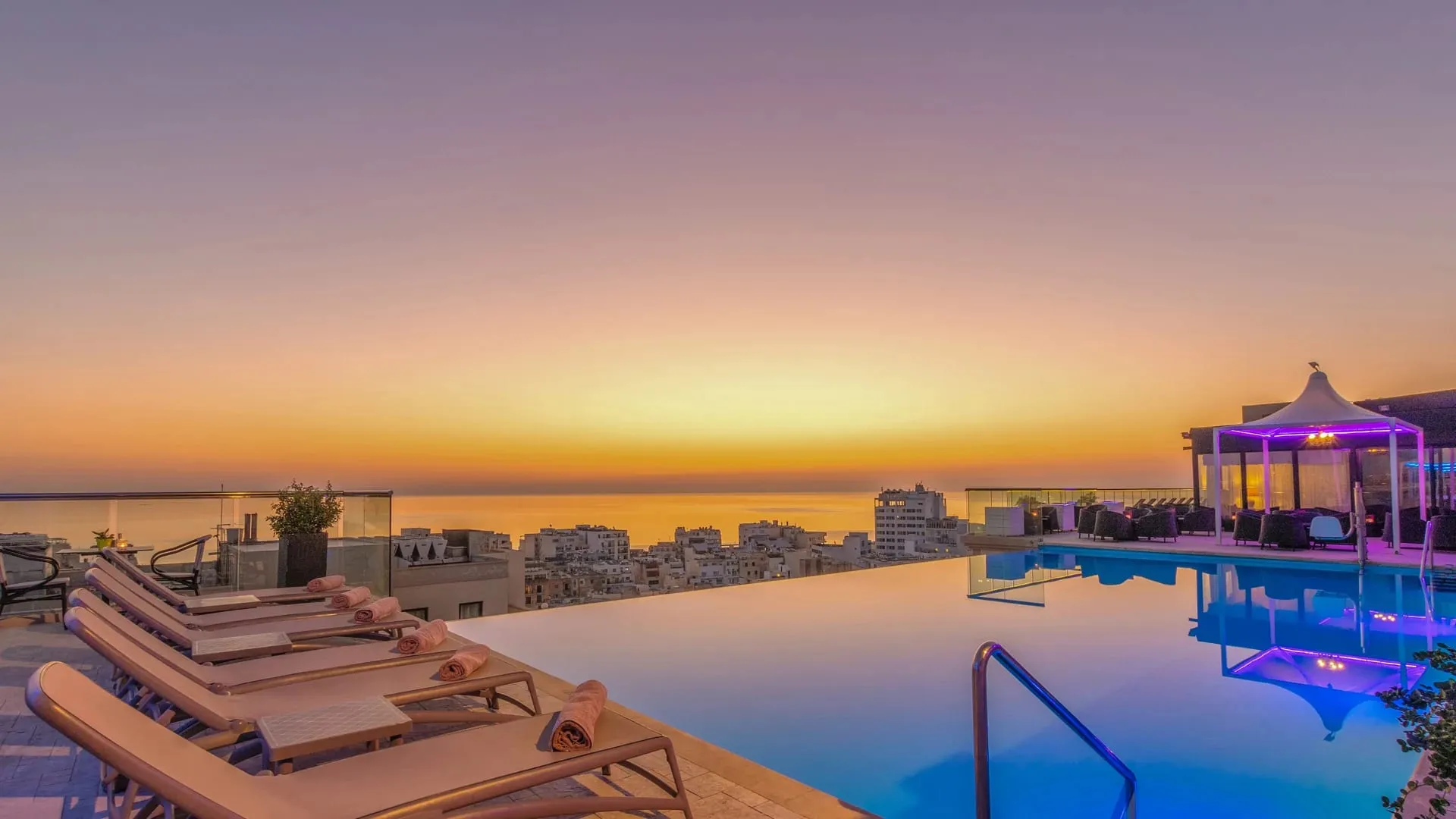 The rooftop pool at AX The Palace, Sliema, at sunset