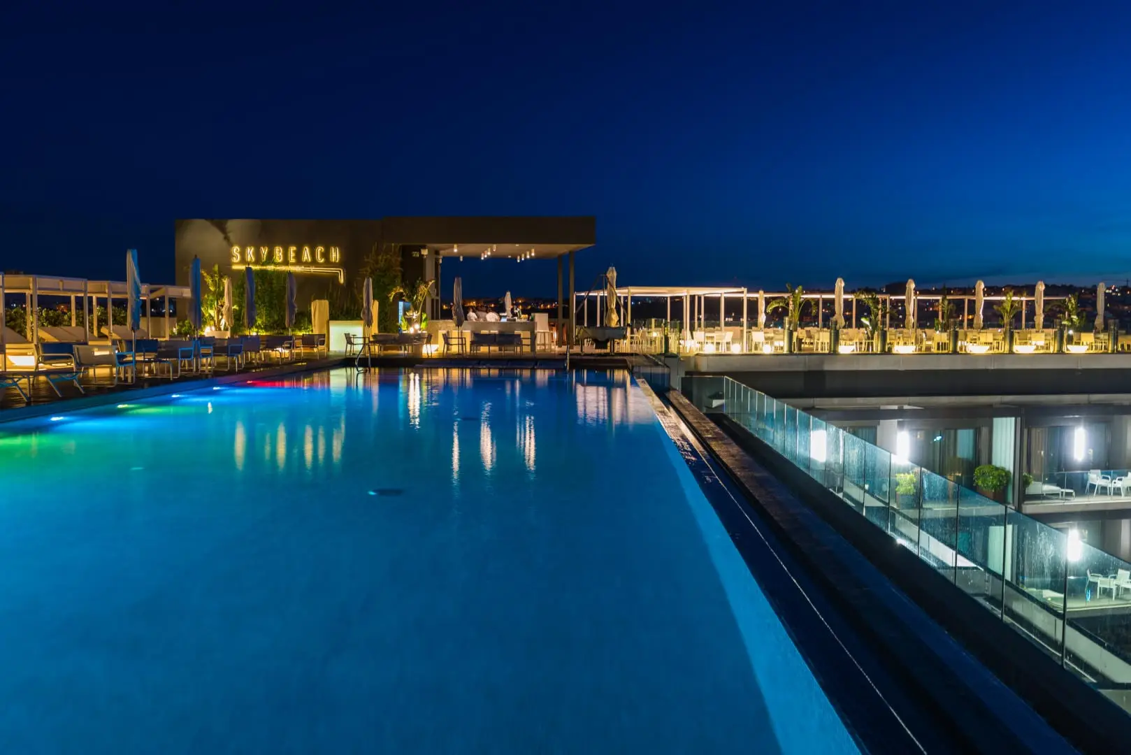 The Sky Beach rooftop pool and bar lit at blue hour