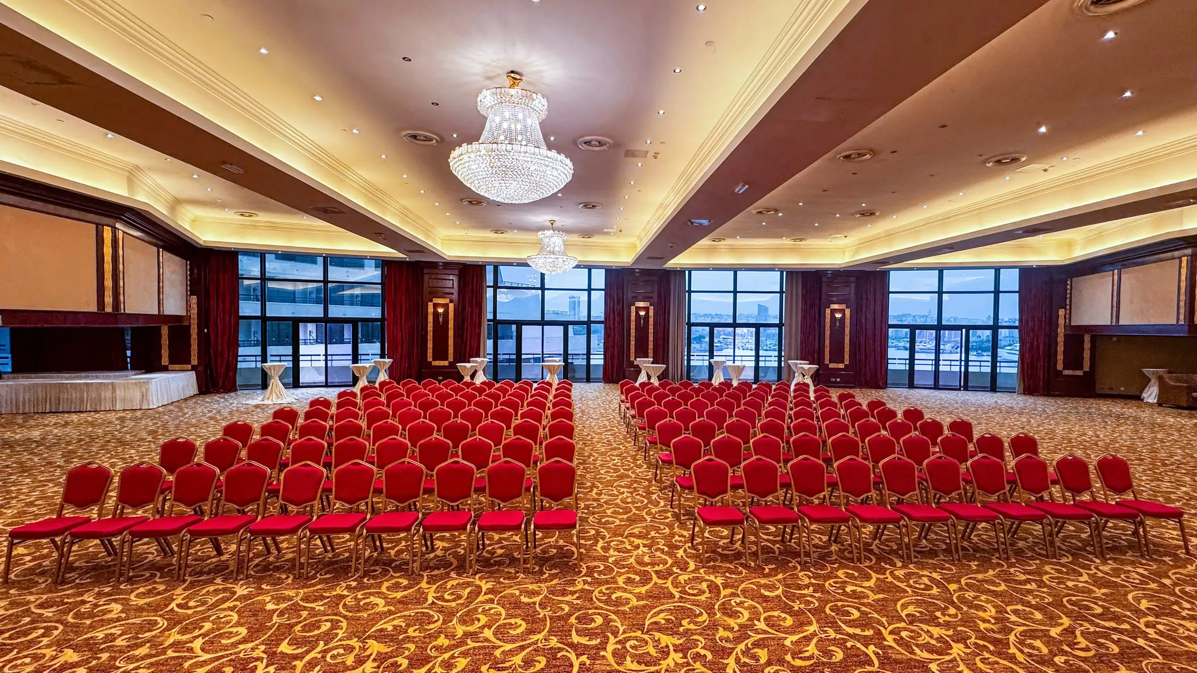 The Grand Ballroom set theatre-style under crystal chandeliers, with harbour views through the windows