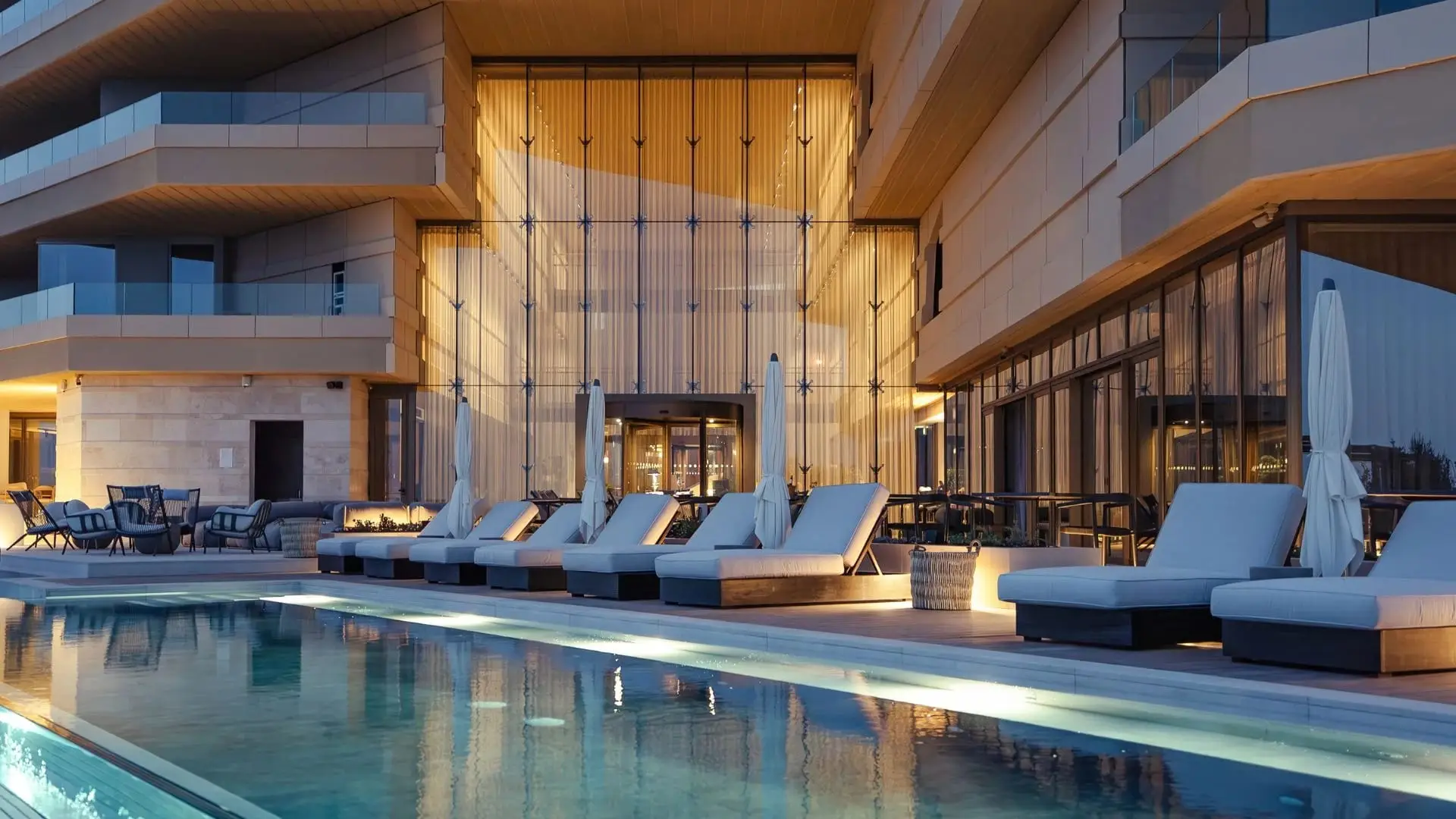 Loungers beside the pool under the hotel’s stone façade