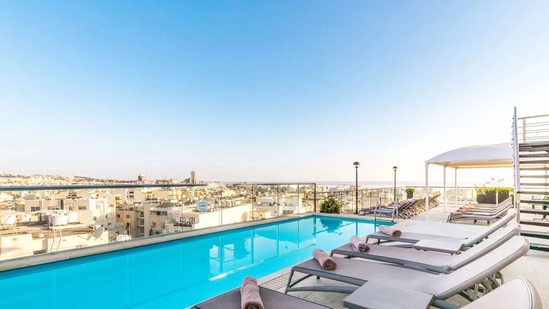 The rooftop pool at AX The Victoria, above the rooftops of Sliema