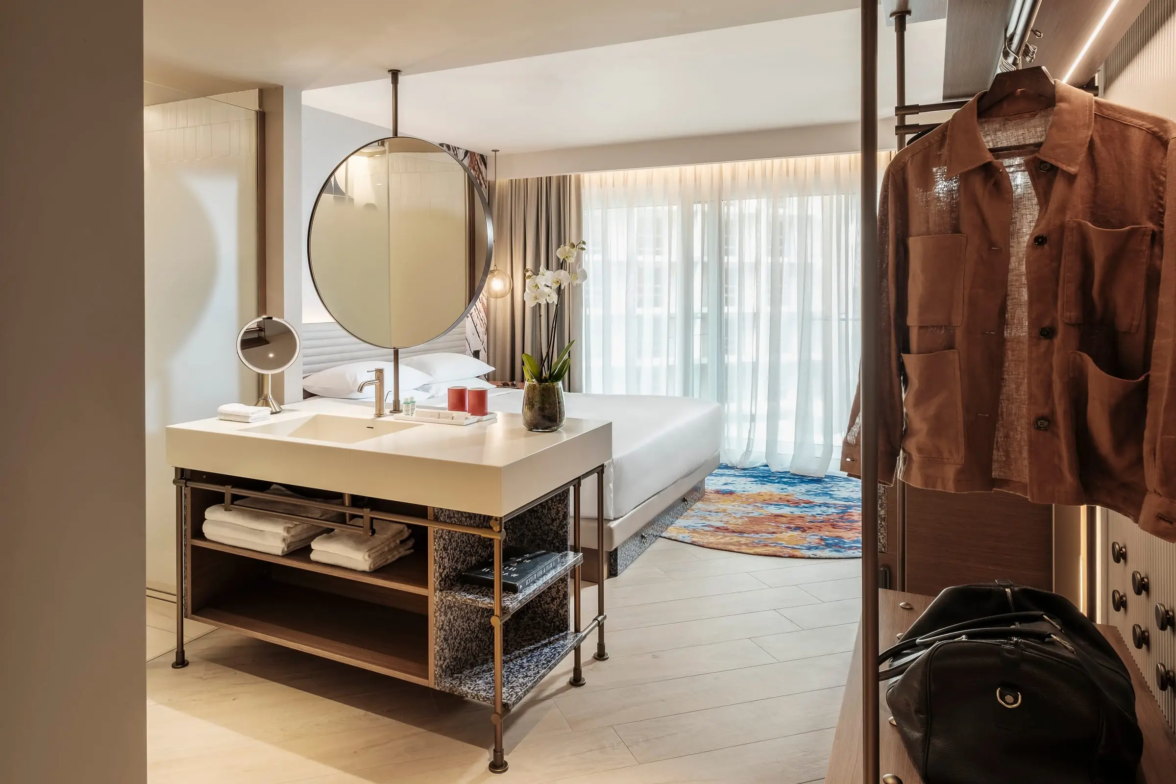 A guest room with an open wardrobe and vanity