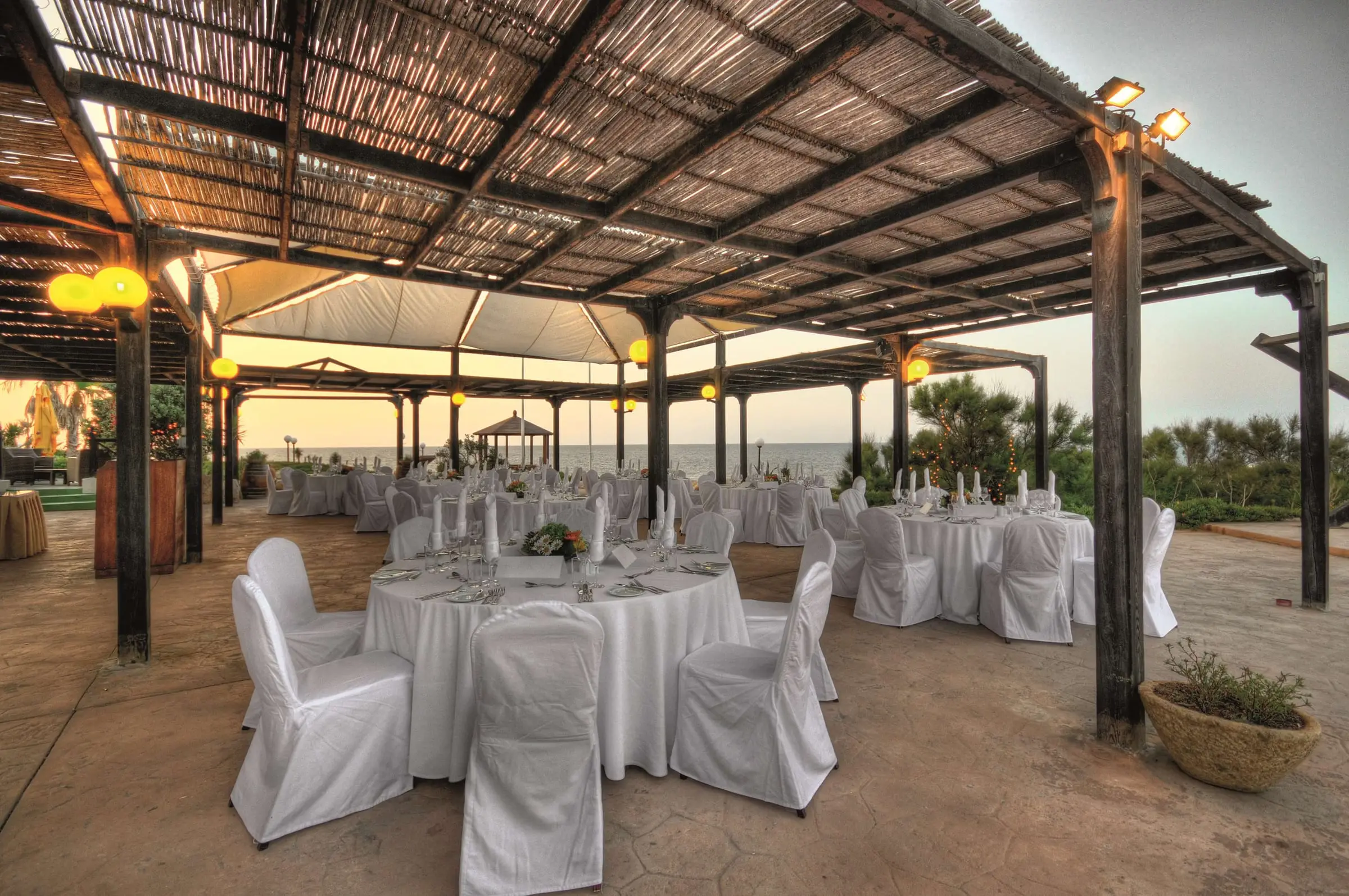 A pergola terrace at the Radisson Blu Resort, St Julian’s, set with round tables for dinner