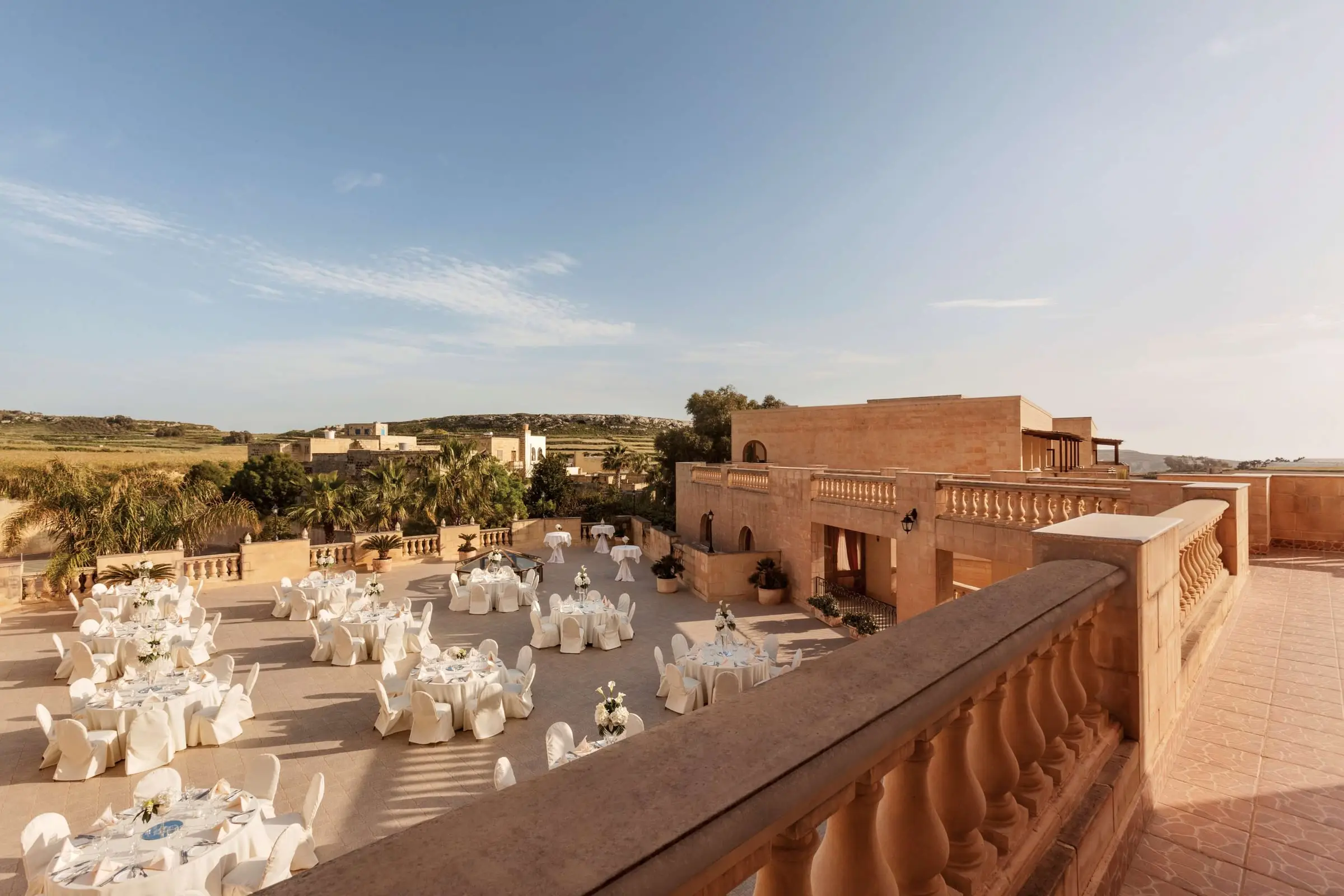 The Kappella terrace at Kempinski Hotel San Lawrenz set with round tables for dinner