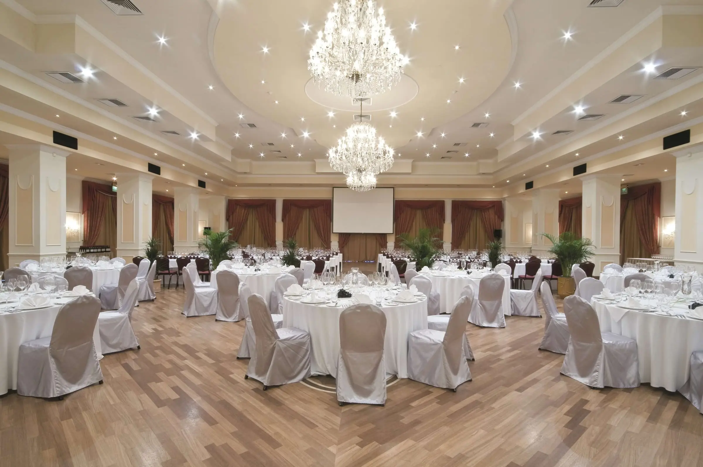 The ballroom at the Radisson Blu Resort, St Julian’s, set with round tables under chandeliers