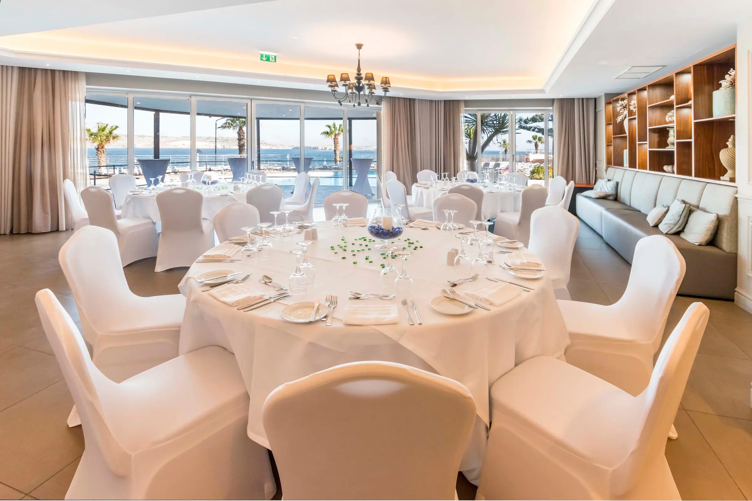 The Sibylle room at DoubleTree by Hilton Malta set with round tables, the sea outside