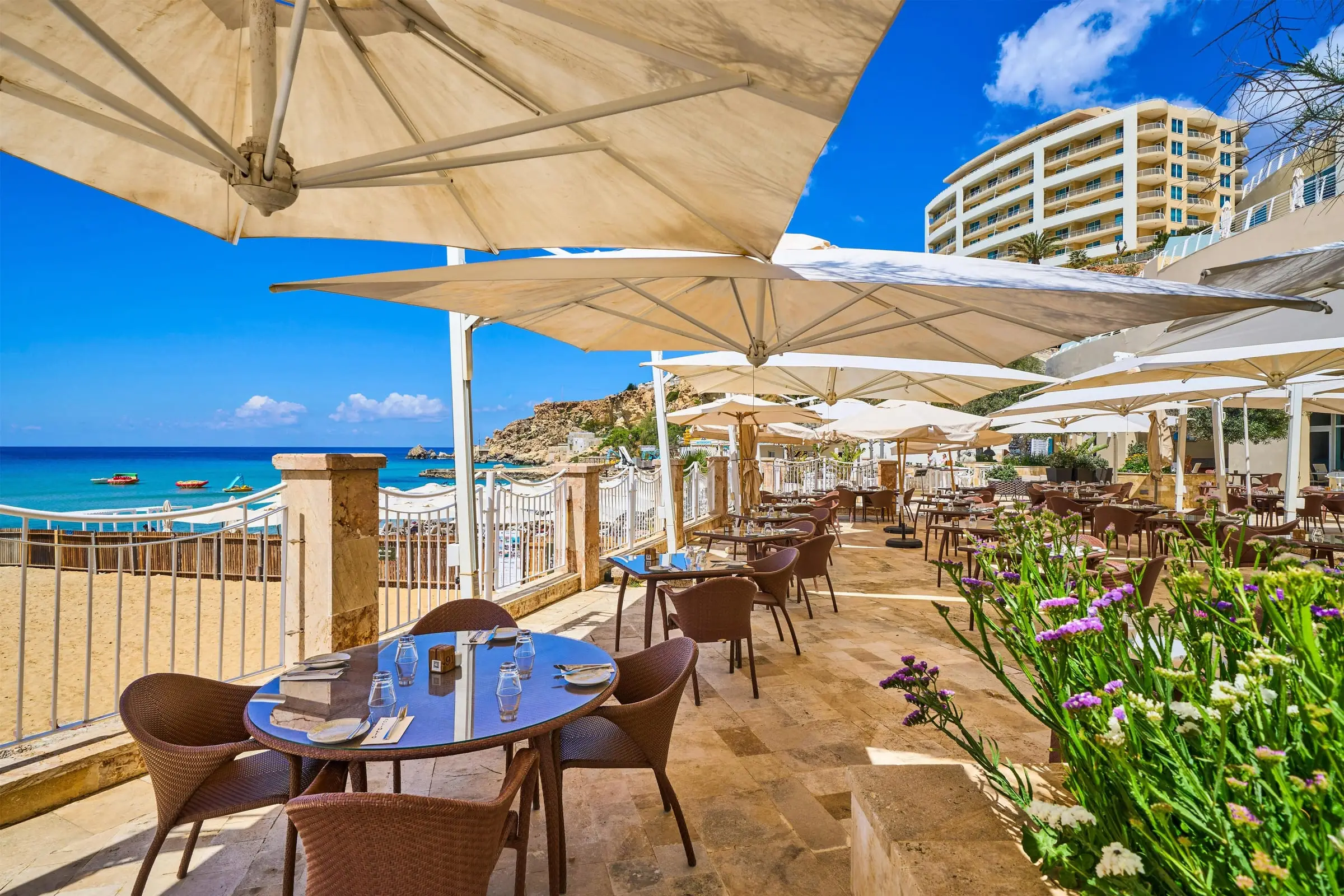 The restaurant terrace at the Radisson Blu Golden Sands under parasols, above Golden Bay