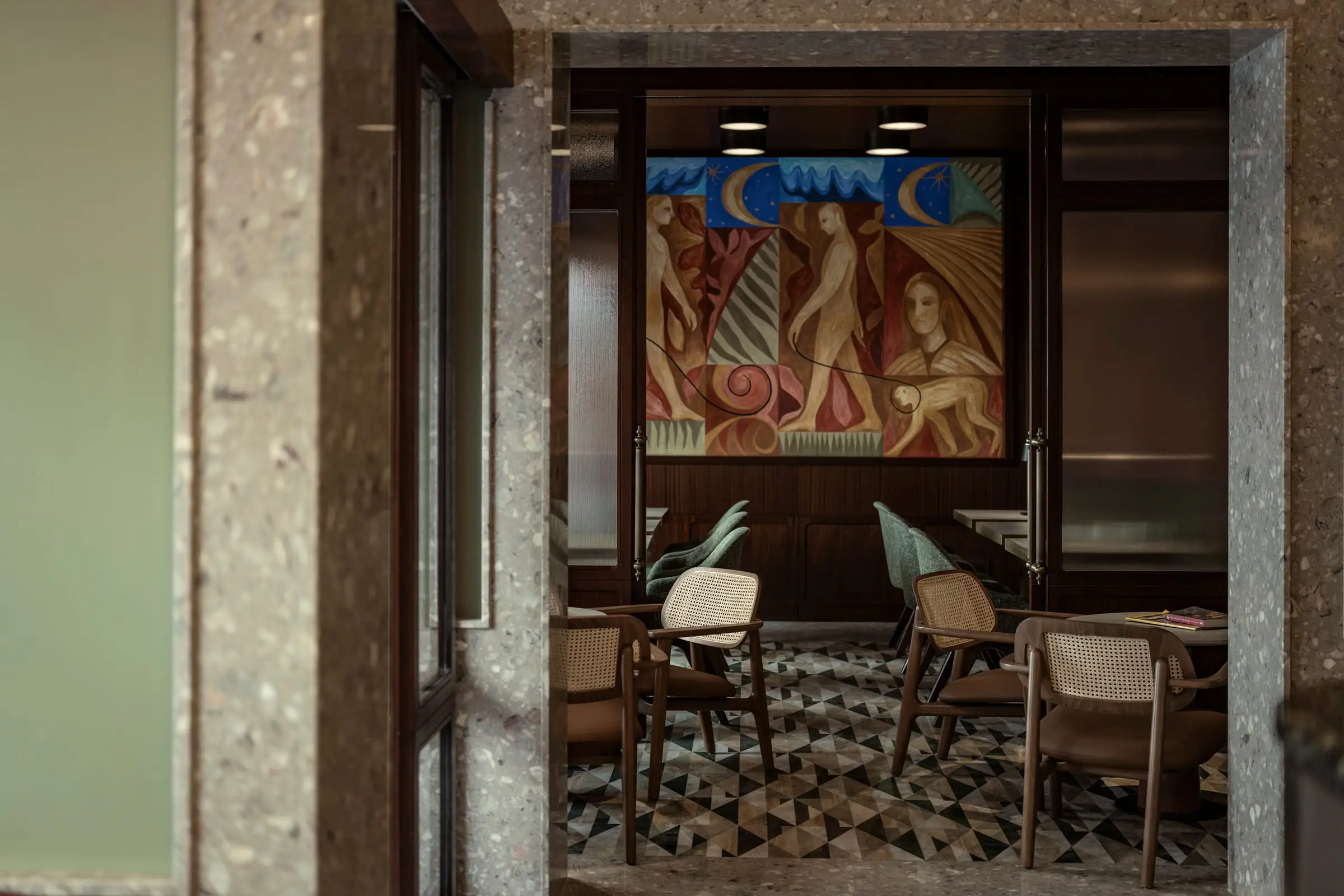 The restaurant, its tables before a large painted mural