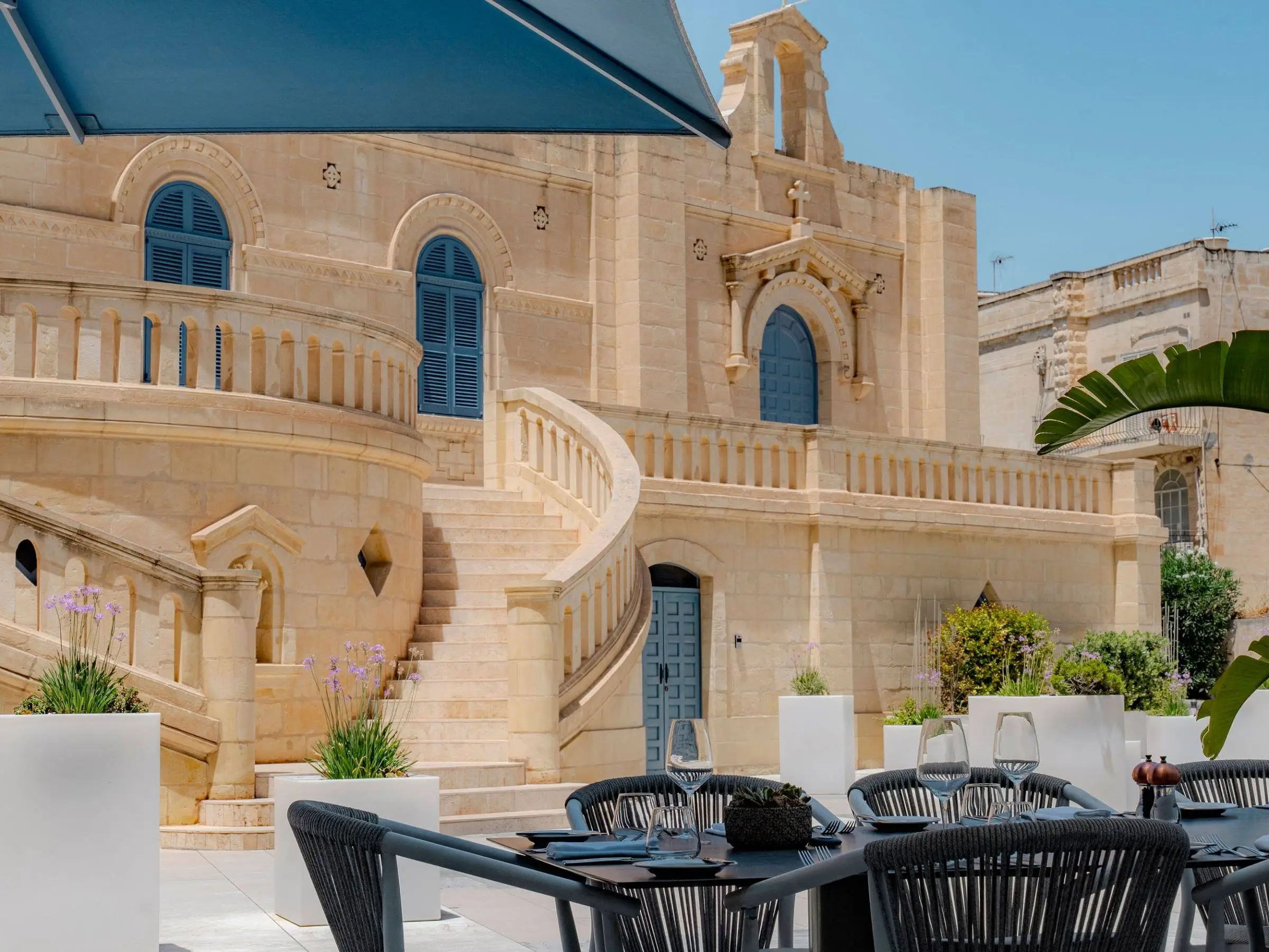 Tables on the terrace of Seed Brasserie, below the staircase of the Santa Rita priory