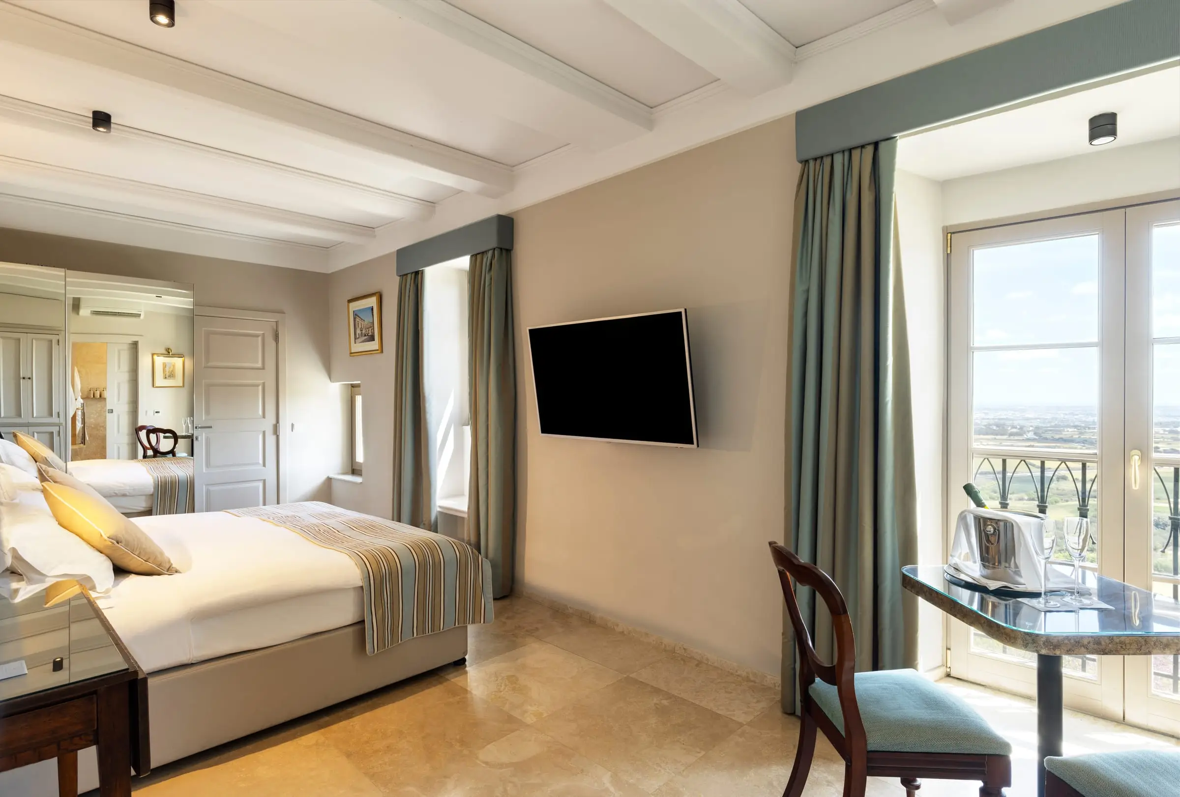 A guest room with French windows opening onto a balcony