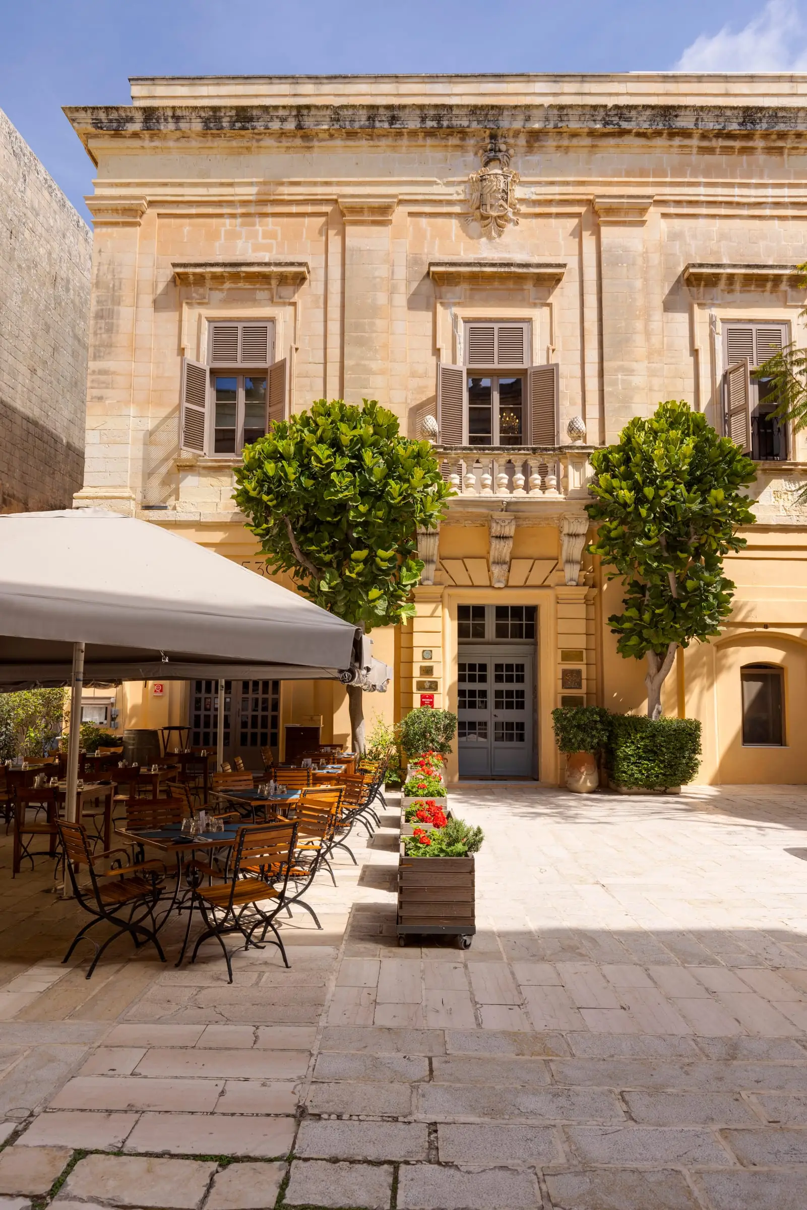 The Xara Palace's facade on Misraħ il-Kunsill in Mdina, with the trattoria's tables in the square