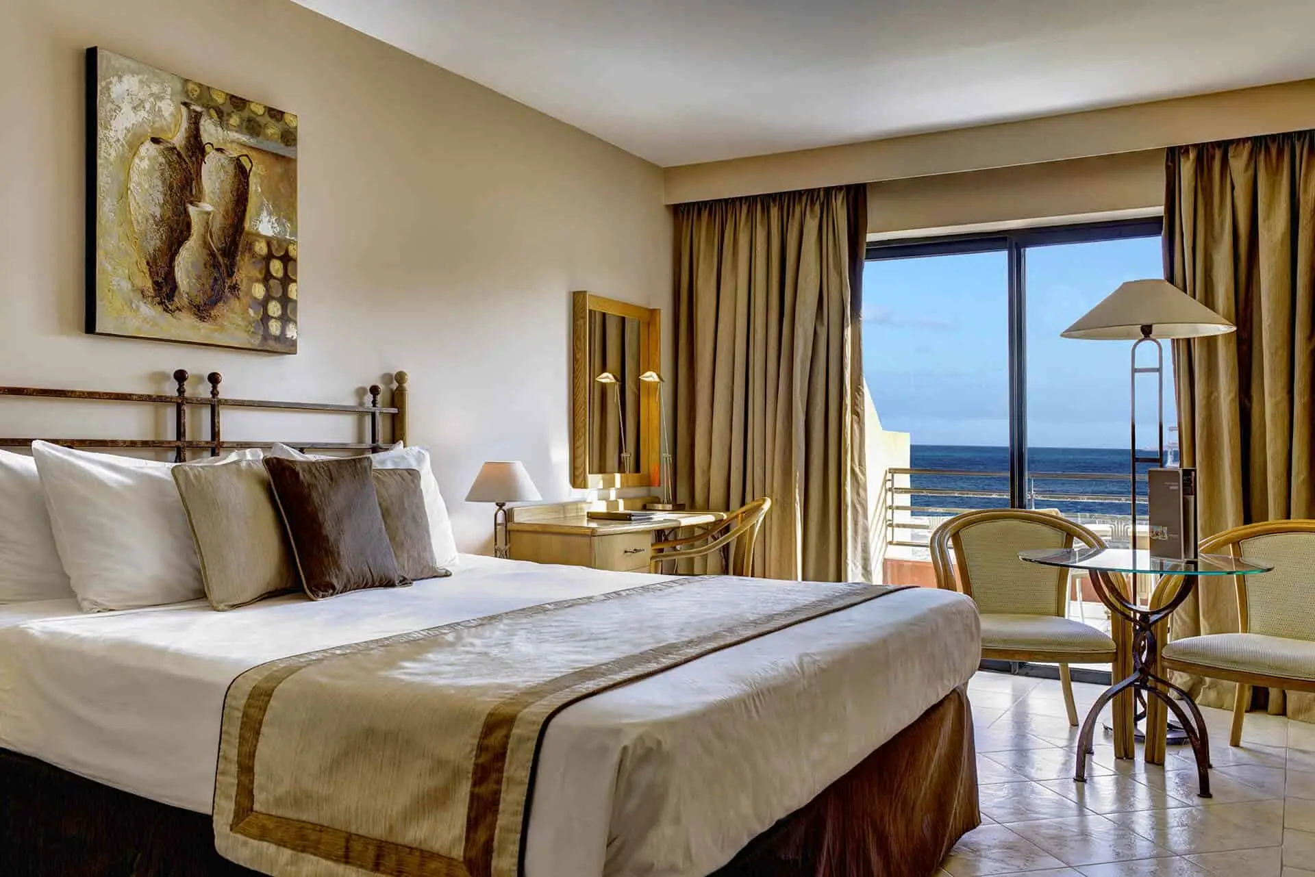 A sea-view guest room with a double bed and a small table by the window