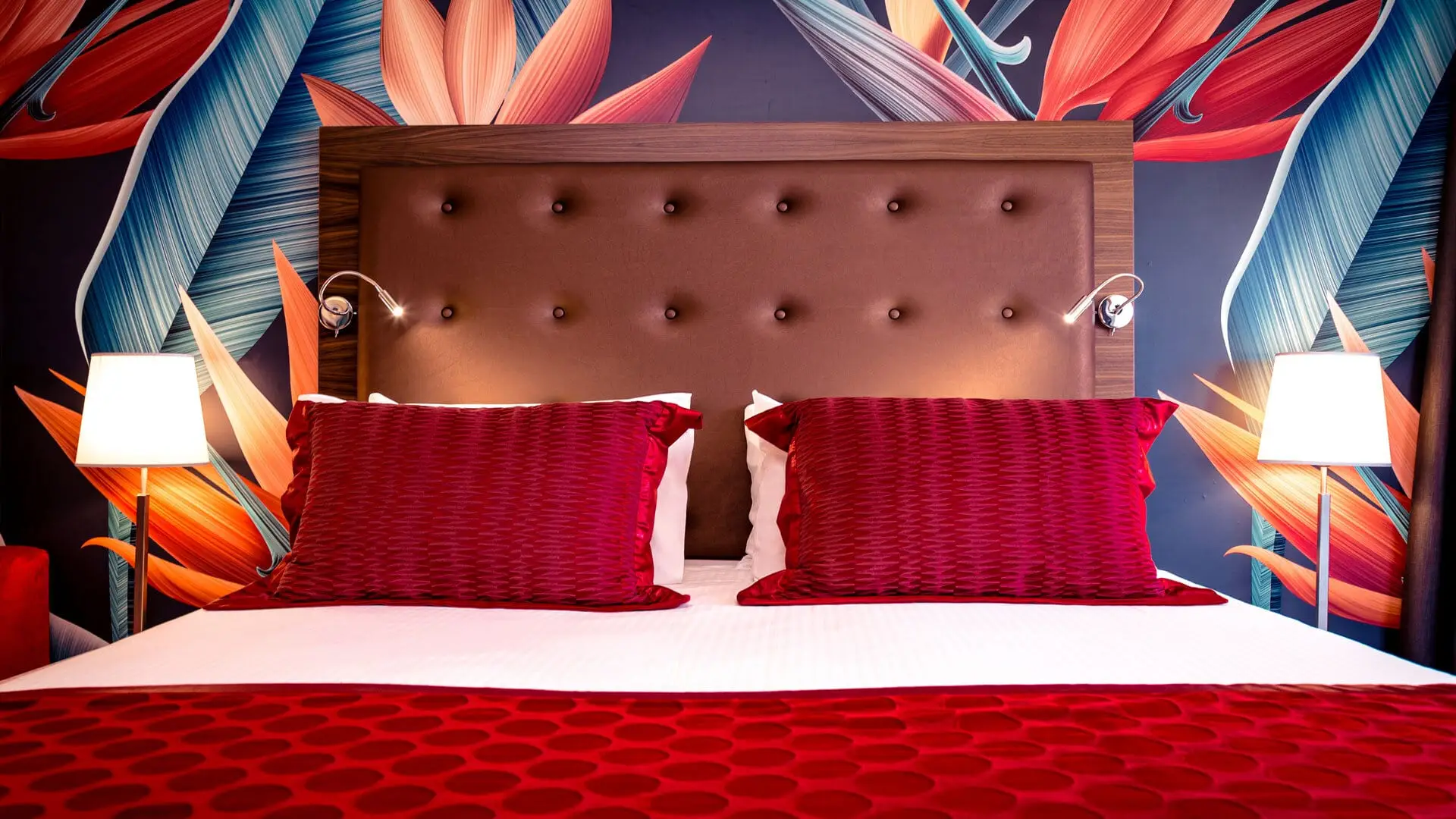 An executive suite at AX The Victoria, with a tropical-print wall behind the bed