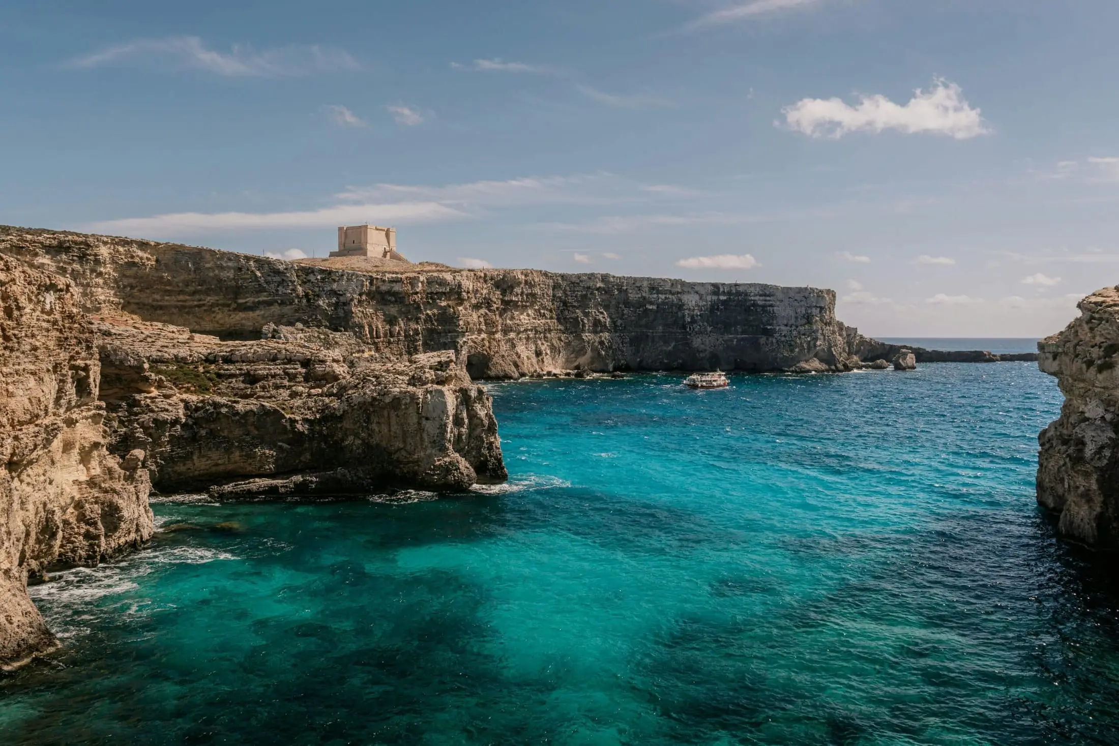 Saint Mary’s Tower above the cliffs and clear water of Comino