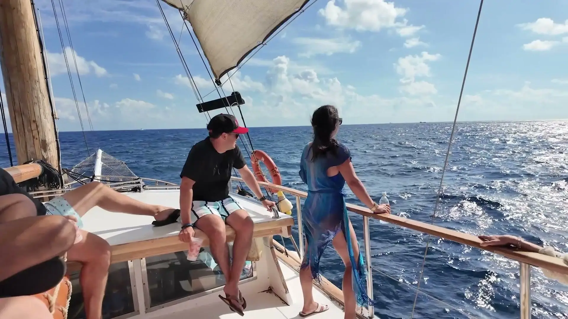 Guests at the rail of a schooner under sail on open sea