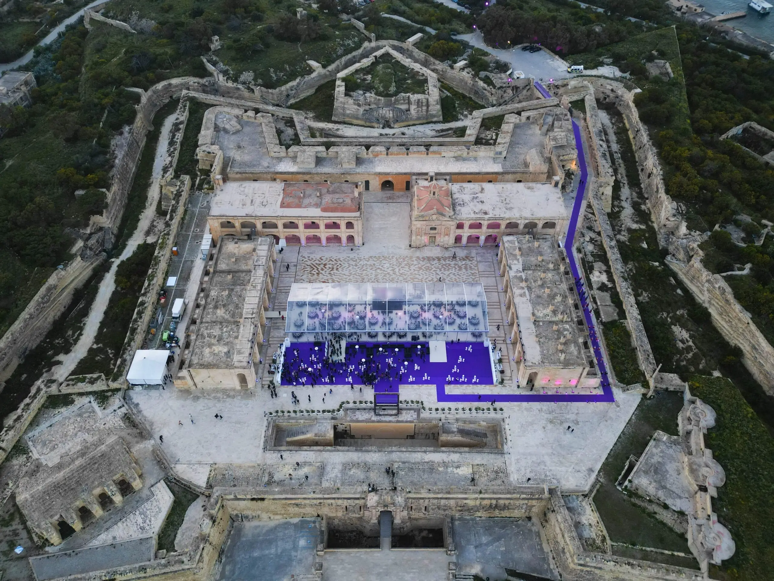 Fort Manoel from the air at dusk, a clear-roofed marquee laid for dinner on its parade ground
