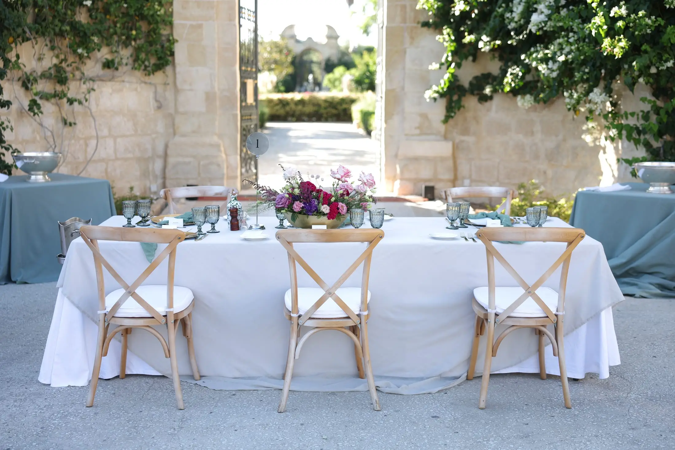 A high table laid for a private dinner in a walled Maltese garden