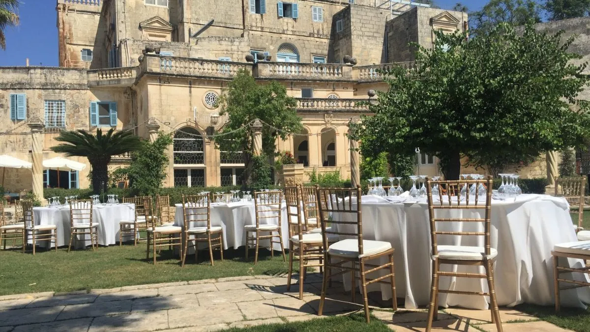Round tables laid on the lawn before the façade of Villa Bologna
