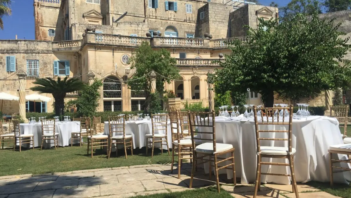 Round tables laid on the lawn before the façade of Villa Bologna