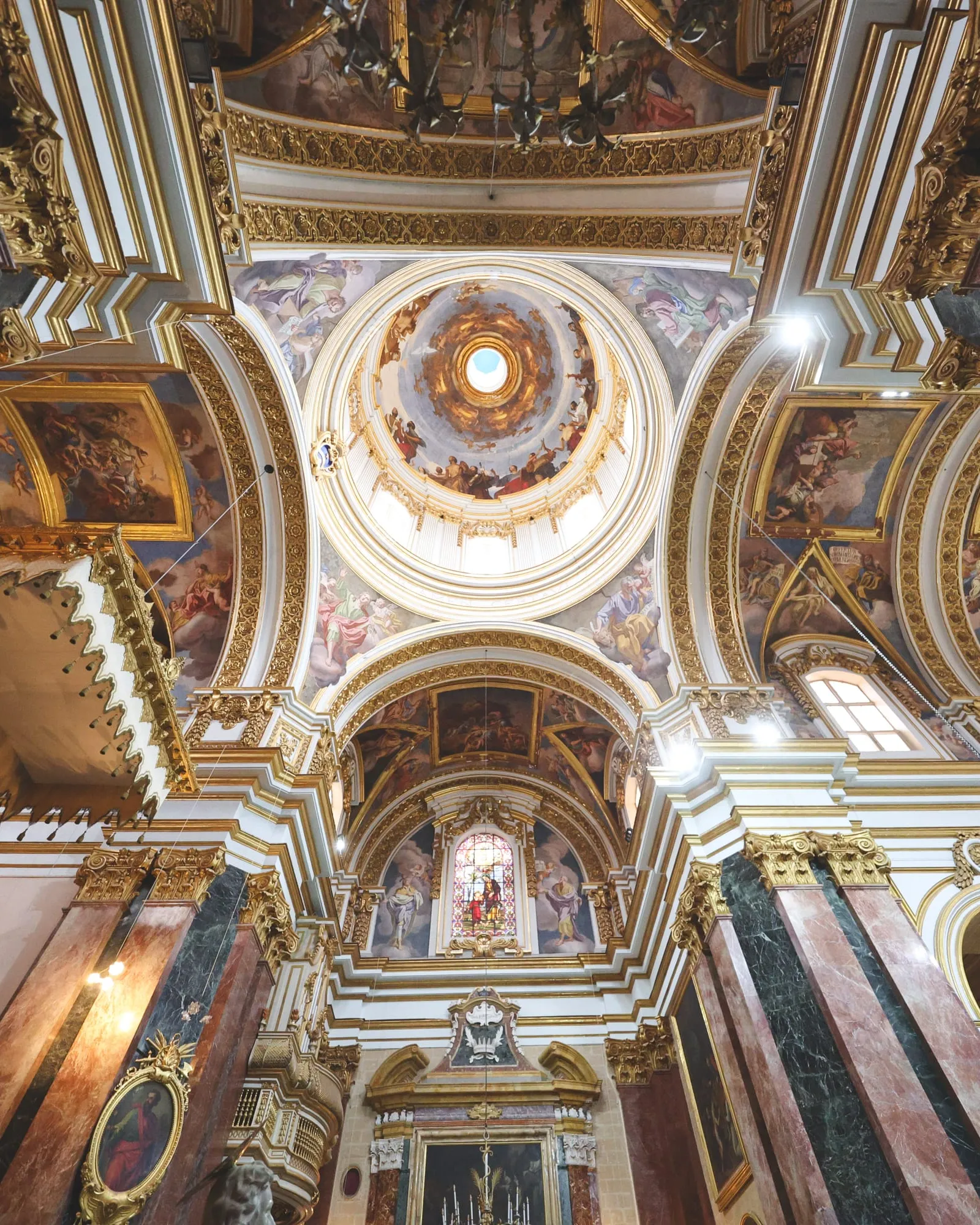 The painted dome and vaults of Mdina Cathedral seen from the nave floor