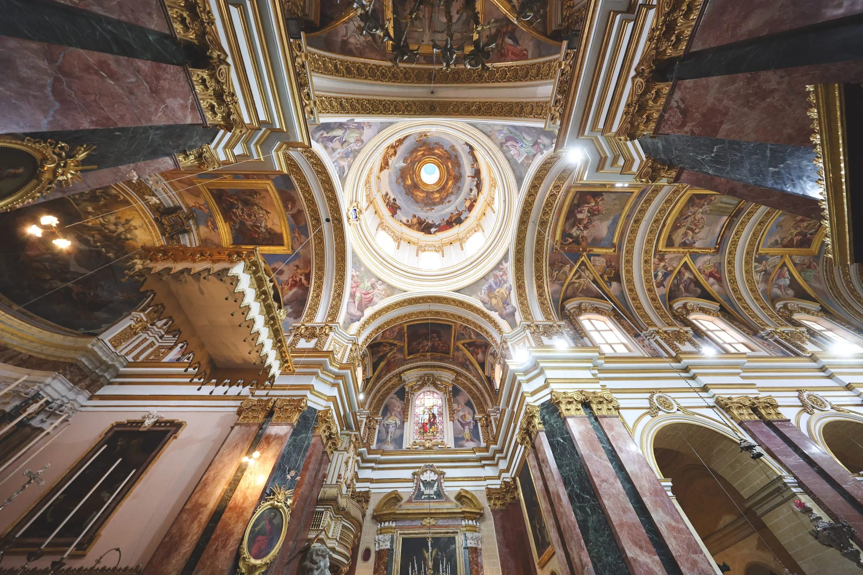 The painted dome and vaults of Mdina Cathedral seen from the nave floor