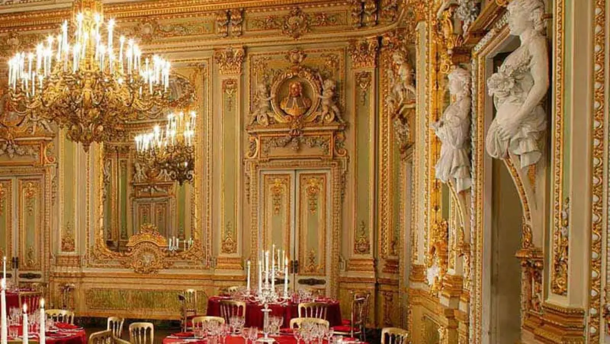 The gilded ballroom of Palazzo Parisio laid with round tables