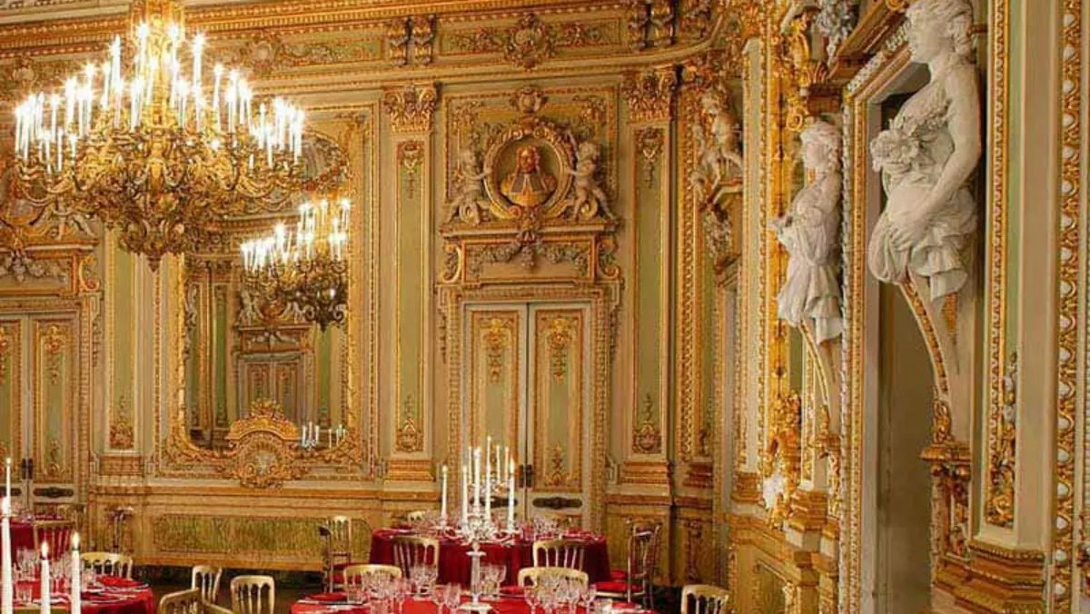 The gilded ballroom of Palazzo Parisio laid with round tables