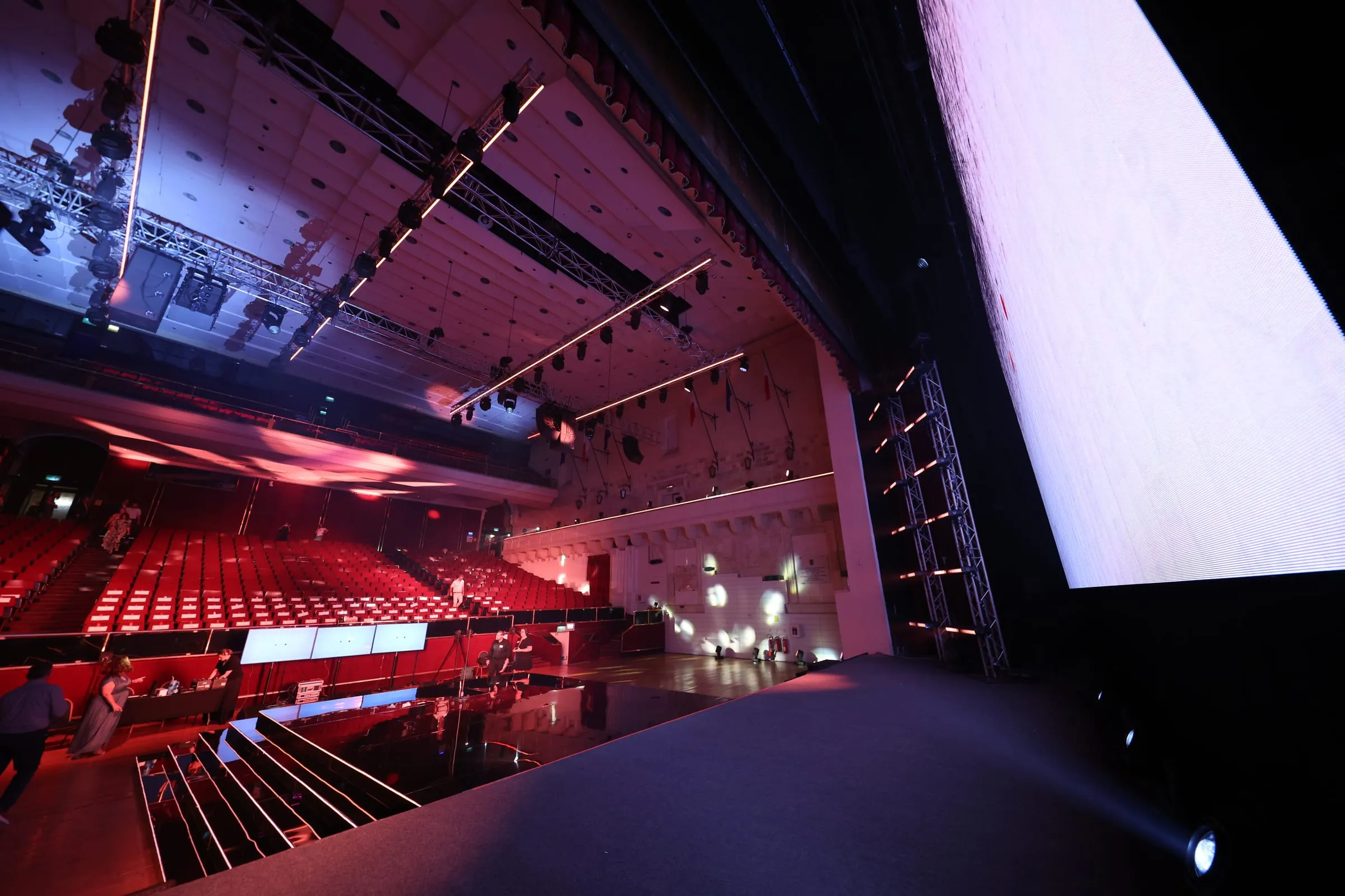 Republic Hall seen from the stage, tiered seating and production rigging lit in red