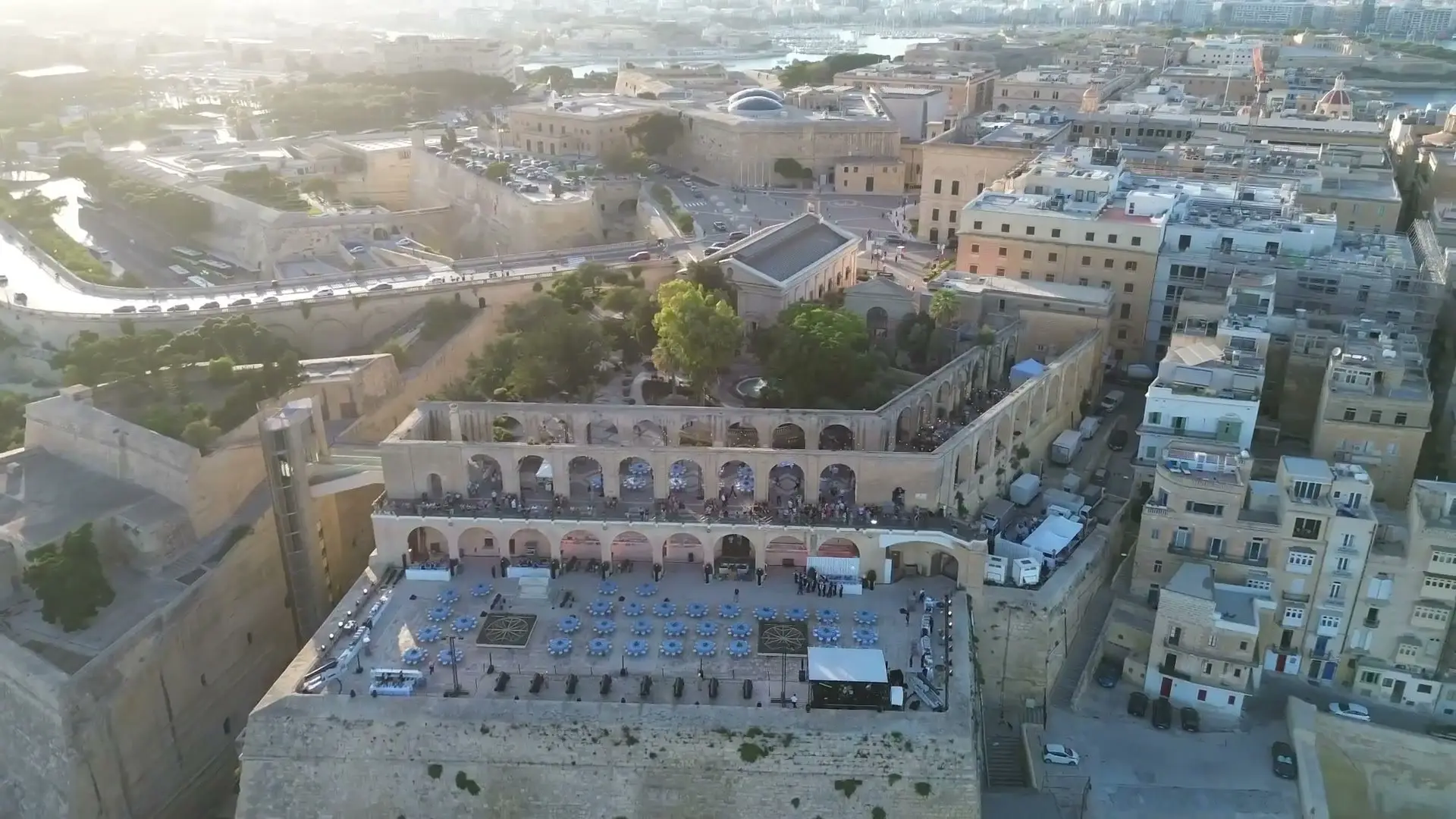 The Saluting Battery from the air, laid with dinner tables below the arches of the Upper Barrakka Gardens, Valletta around it