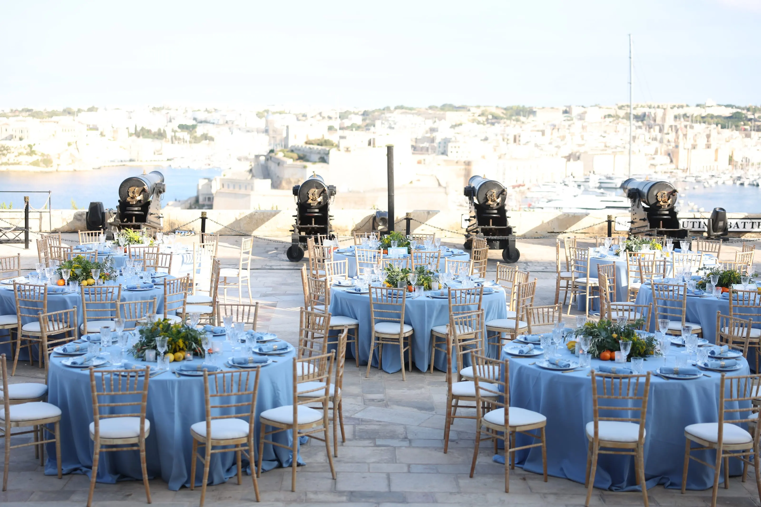 Tables laid in blue on the Saluting Battery, its cannons and the Three Cities beyond
